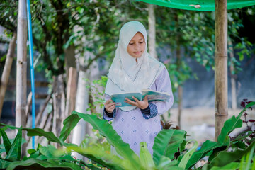 Naklejka na ściany i meble muslim girl homework in the garden