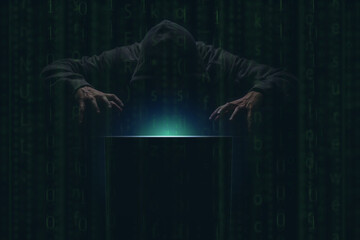 hacker over a screen with green binary code. Crime and Information Theft and Computers