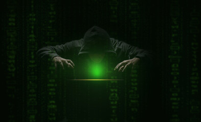 hacker over a screen with green binary code. Crime and Information Theft and Computers
