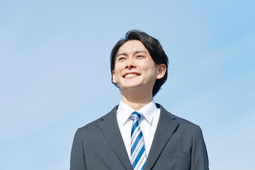 青空バックの笑顔のビジネスマンのポートレート