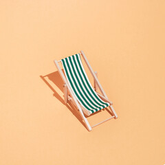 Sandy beach with sunbed. Minimal concept of summer and vacation in the tropics by the sea. Trendy collage on pastel yellow background.Creative art minimal aesthetic