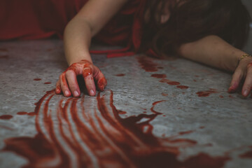 Dead woman in red dress bloody on the floor by murderer at crime scene.