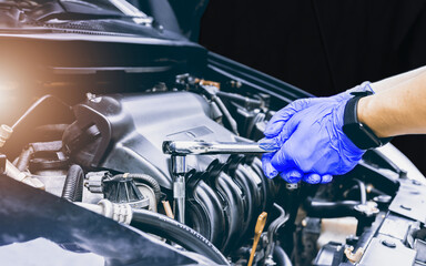 Automobile mechanic repairman hands repairing a car engine automotive Safety inspection test engine before customer .Repair service.Services car engine machine concept,