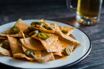 Mexican nachos chips with american cheese, beer and jalapeños in Mexico Latin America	