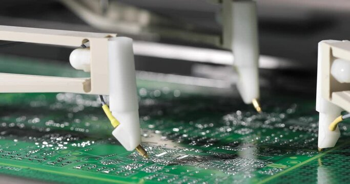 Close-up working moving needles on automatic equipment manufactoring of microchips. Process of production of microcircuits and circuit boards, micro soldering. High-tech technologies.