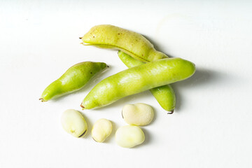 Fresh broad beans on a solid color background