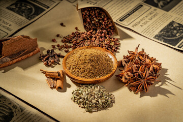 Chinese traditional seasoning five spice powder and raw materials on retro background
