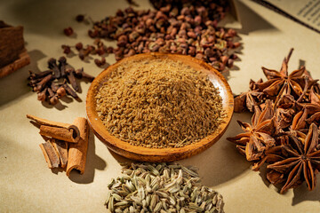 Chinese traditional seasoning five spice powder and raw materials on retro background
