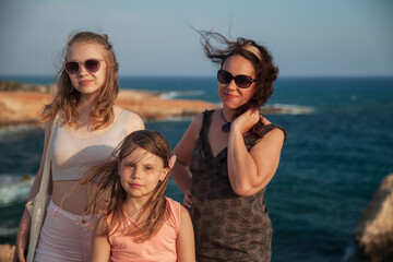 Happy mother with daughters are on a beach