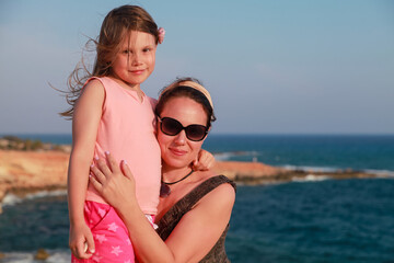 Fototapeta premium Happy mother with smiling little daughter are on a beach