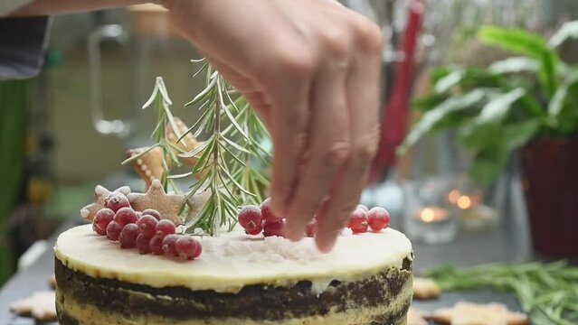 Decorating of gingerbread layer cake with pearl sugar.
