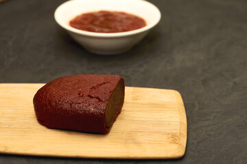 basturma on a wooden cutting board next to a plate with spices
