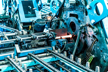 Machine for induction heating of metal. A metal rod heated in an induction furnace. Hot metal processing. Metalworking in the industrial workshop at the factory. - Powered by Adobe