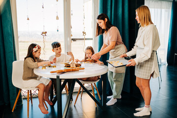 Big family with two moms cooking with their children cookies. Loving people and happy childhood hobbies