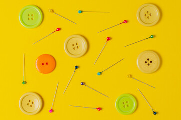 Sewing accessories on a yellow background. Closeup.