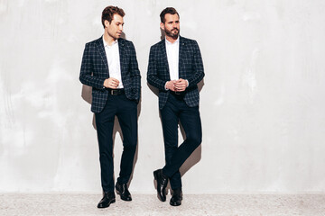 Portrait of two handsome confident stylish hipster lambersexual models. Sexy modern men dressed in...
