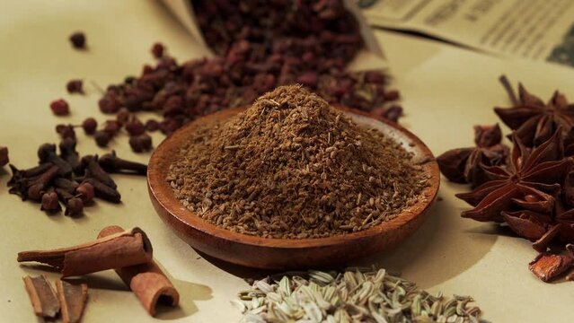 Chinese traditional seasoning five spice powder and raw materials on retro background
