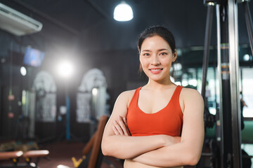 Fototapeta na wymiar young Asian woman person exercise in fitness gym for building a beautiful slim body, healthy training of athletic female in sport lifestyle, attractive girl doing weight active wellness in happy