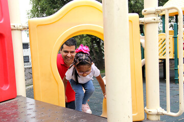 Latino and brunette single dad and daughter play in the park, get on rides and spend quality time...