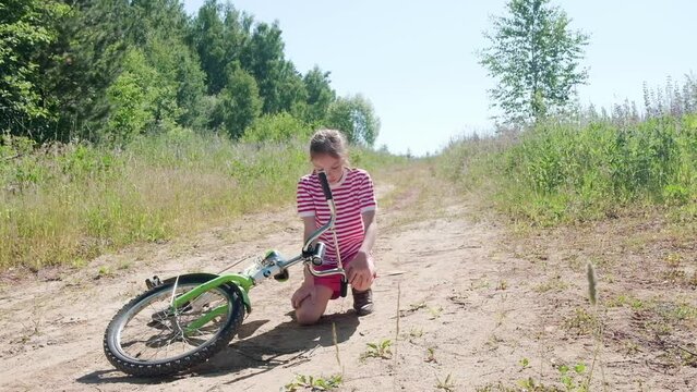 Portrait of a Caucasian girl 9-10 years old, a teenager, fell off her bike and suffers from pain. Leg injury