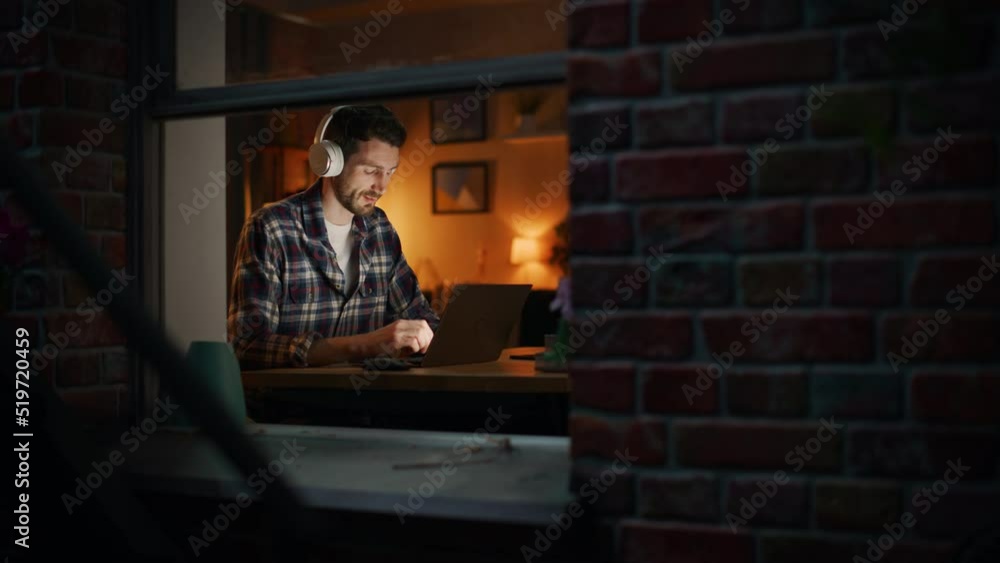 Poster creative professional man opens laptop, puts on headphones and starts working. it specialist writes 