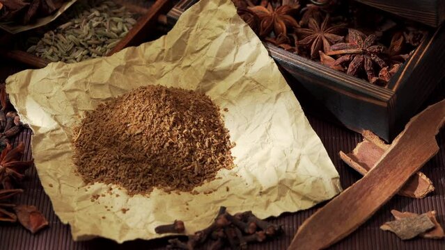 Chinese traditional seasoning five spice powder and raw materials on retro background