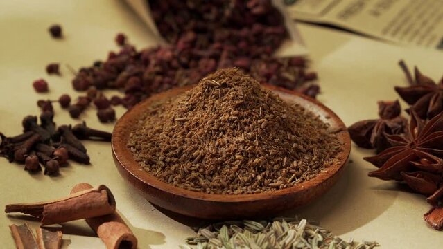 Chinese traditional seasoning five spice powder and raw materials on retro background
