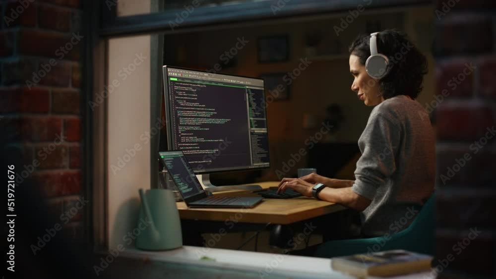 Poster Brazilian Female Programmer Working on Computer at Home. Brilliant Female IT Programer Using Desktop Computer Late Night. Professional Developer Programming Code . Shot Into the Window From Outside.