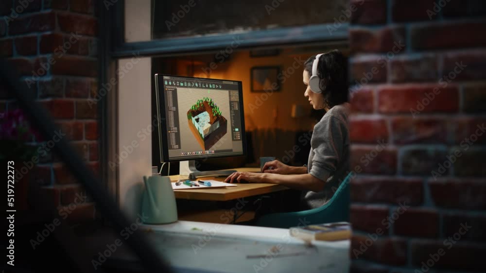Aufkleber Female Video Game Designer Works on a New 3D Level on Her Personal Computer. Focused Woman Creating Metaverse and Design Video Game. Shot Into the Apartment Window Late at Night