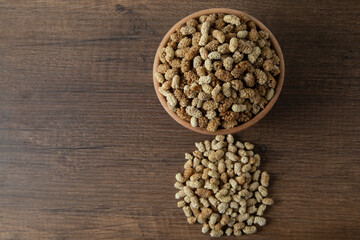 Bowl full of dried mulberry on a wooden background
