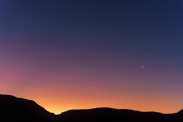 Sunset sky, crescent moon and scenic view of Karoo National Park, Beaufort West, Western Cape, South Africa