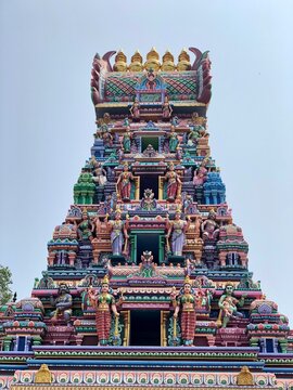 Hindu temple in Tamilnadu, India. Tower with painted God sculptures against blue color sky background.