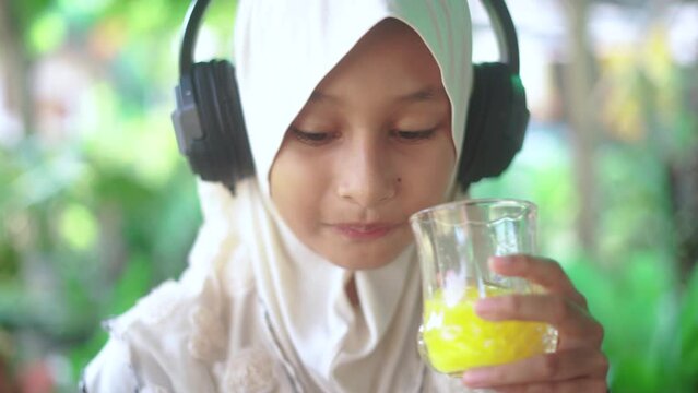 Islamic girl drinking orange juice
