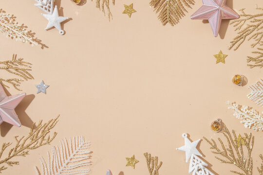 Festive Christmas and New Year backround with golden white holiday decoration on pastel beige with copy space. Top view. Merry Christmas monochrome concept