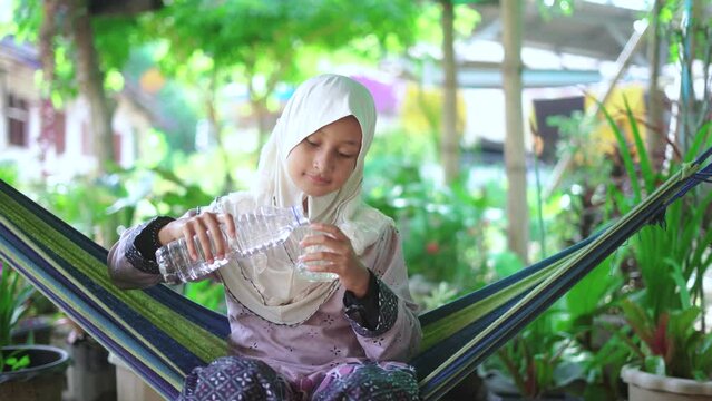 Islamic girl pouring water into a glass