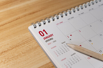 Jan month 2022 Calendar page with pencil business planning concept on wooden background