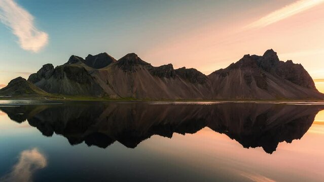 Colorful sunrise over Vestrahorn mountain and water reflection on coastline in Stokksnes on the southeastern at Iceland