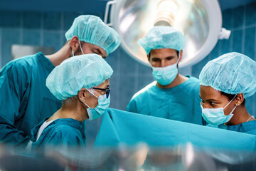 Group of surgeons at operation in operating room at hospital. Surgery, medicine and people concept