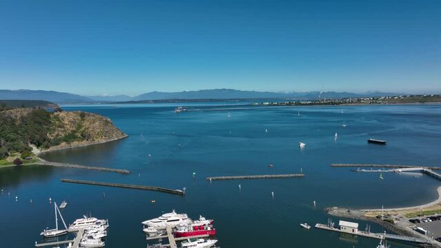 Aerial view over top of the Anacortes marina looking towards the horizon sun blue skies.