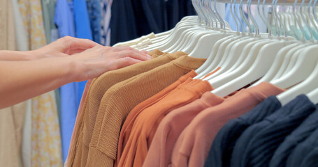 Woman choosing sweatshirt in the store, close-up view