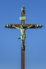 Ancient landmark crucifix monument, weathered bronze statue of Jesus Christ on the Cross isolated...