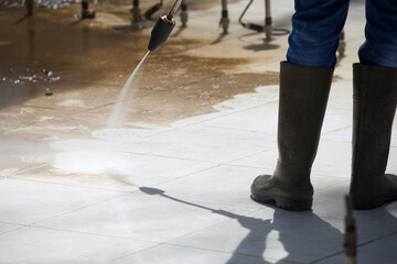 Worker Cleaning an Empty Fountain by Pressure Washer - 519734447