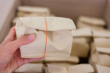 Hand holding paper bags for packing parcels.