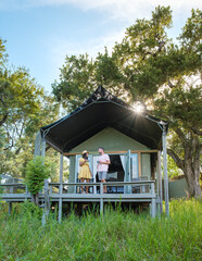 couple on safari in South Africa, Asian women and European men at a tented camp lodge during the...