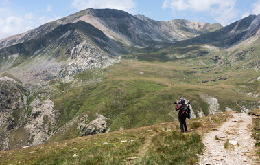 Young photographer taking photos in the mountains