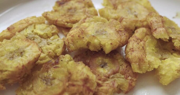 Close-up of a group of fried patacones or tostones freshly cooked and placed on a plate.