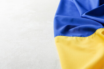 Ukrainian flag on light textured background, space for text