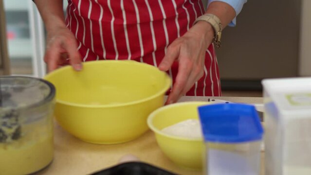 Woman Wearing Red Apron In The Kitchen, Preparing Slovakian Potato Dumplings (Bryndzove Halusky). medium shot