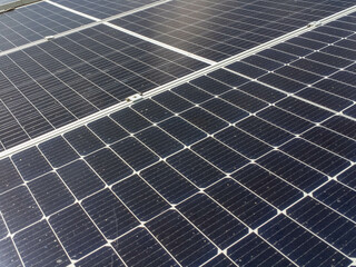 Close-up of blue photovoltaic solar panels mounted on building roof. The concept of sustainable...