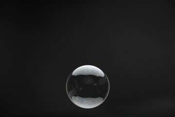 Flying soap bubbles on black background. Abstract soap bubbles with reflections. Soap bubbles in motion background.